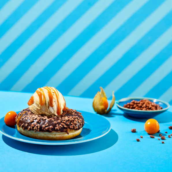 Sjokoladeglassert donut servert med en kule vaniljeis